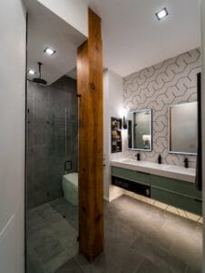 Bathroom remodel in a condo featuring a timber column, heated towel racks, a floating sink, modern tile, & sleek finishes done by 3rd Gen Painting & Remodeling out of Madison WI.